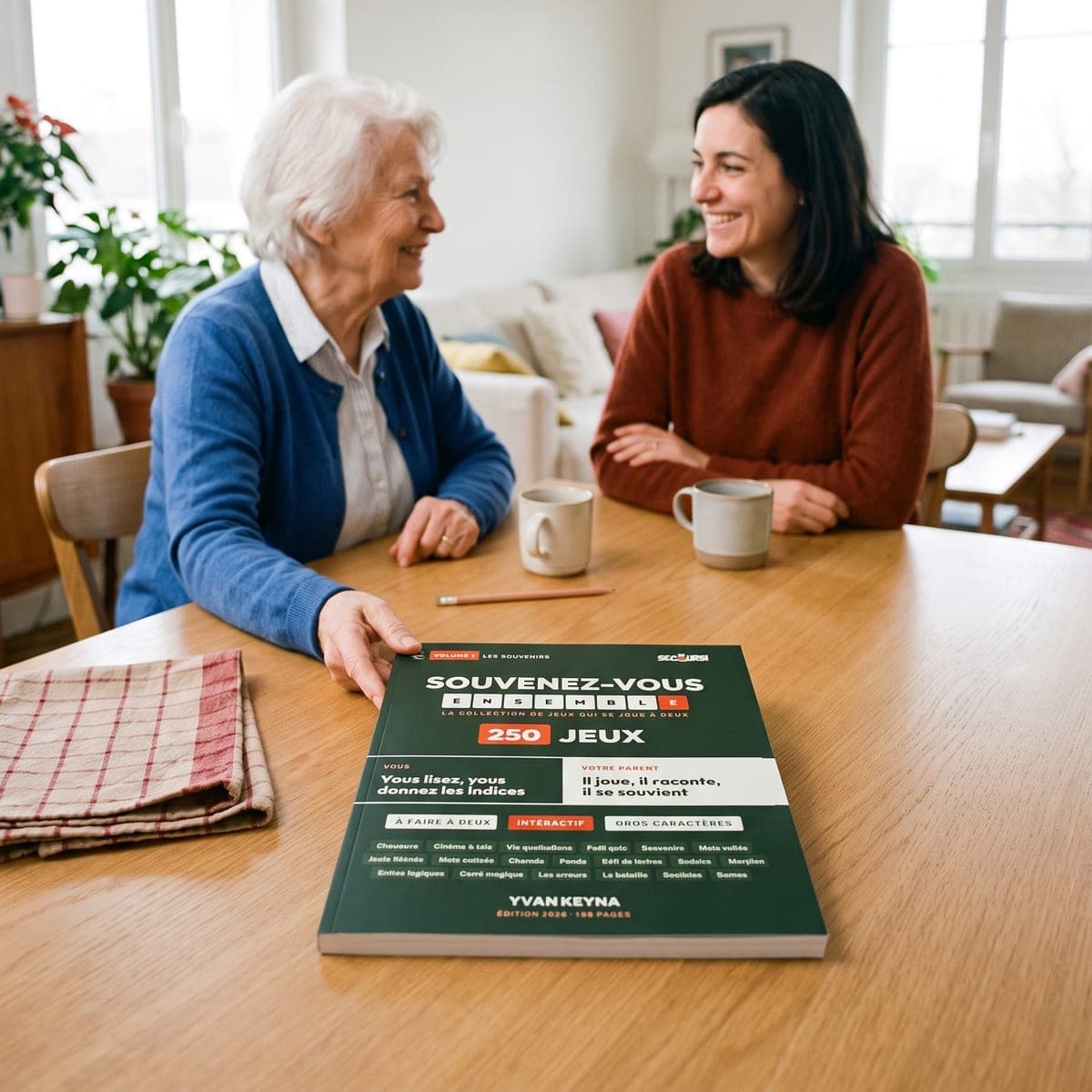 Een oudere moeder en haar dochter lachen samen aan tafel, met het boek ‘Samen herinneringen ophalen’ voor zich